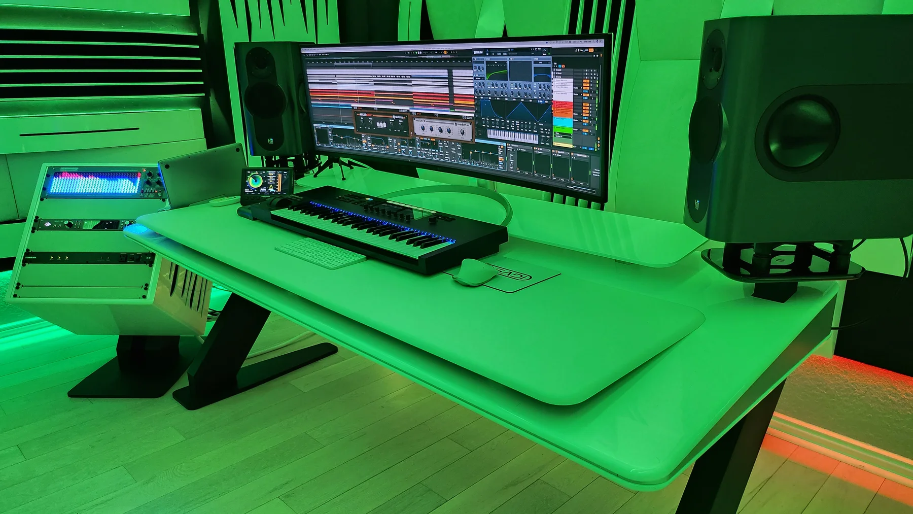 Tasadi’s studio with synthesizer keyboard, studio monitors and music production software